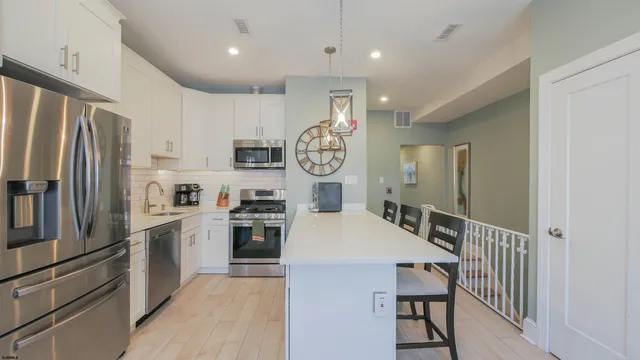 a kitchen with stainless steel appliances granite countertop a stove and a sink