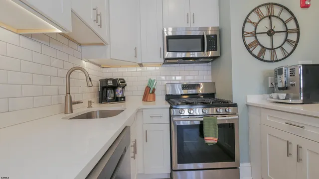 a living room with furniture chandelier and a mirror