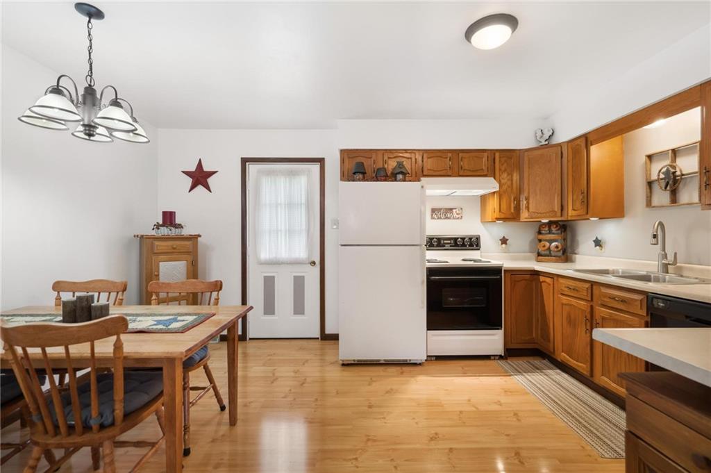205 Ross Road Eighty Four, PA 15330 - Photo 6 of 25 a kitchen with stainless steel appliances granite countertop a stove a refrigerator a sink dishwasher a dining table and chairs with wooden floor