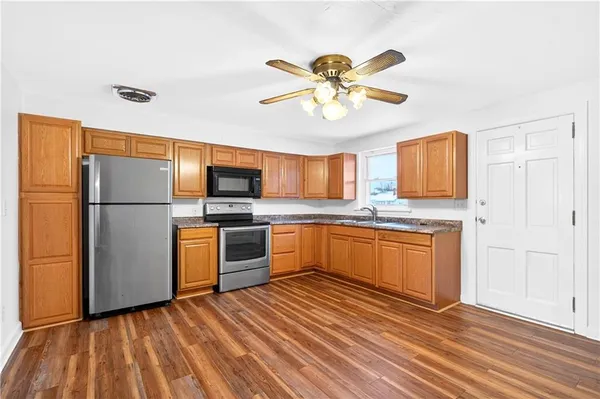 a kitchen with stainless steel appliances granite countertop a refrigerator a stove top oven and sink