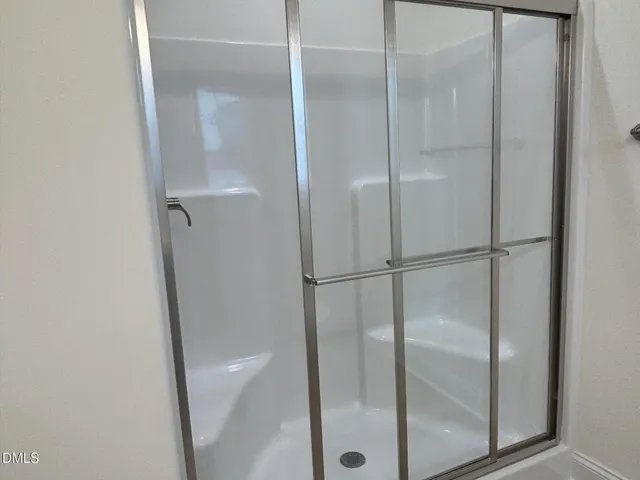 an empty room with wooden floor chandelier and windows