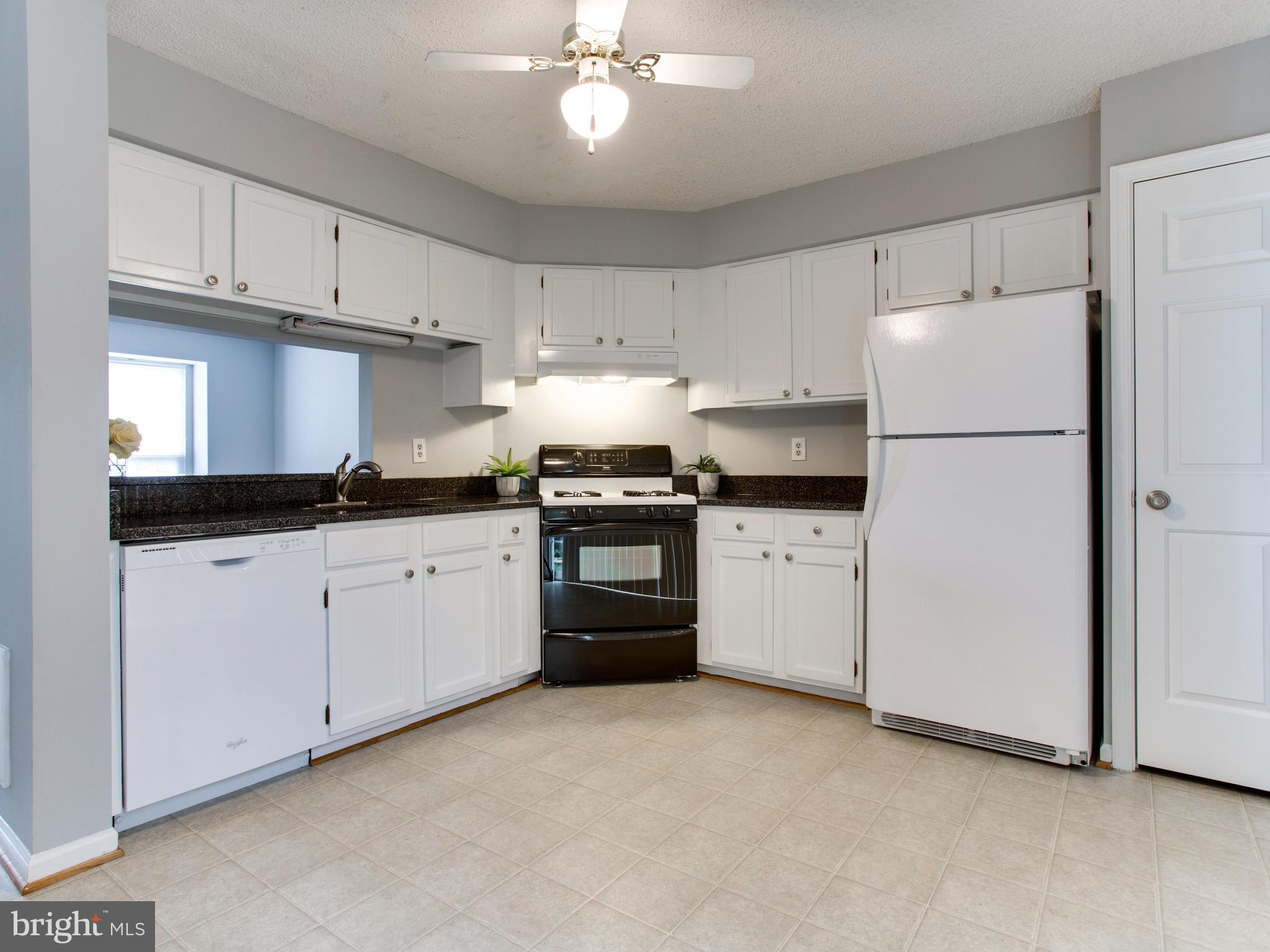 14775 Basingstoke Loop Centreville, VA 20120 - Photo 8 of 21 a kitchen with granite countertop white cabinets and white appliances