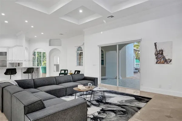 a living room with furniture a chandelier and a window