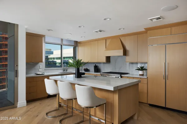 a kitchen with stainless steel appliances granite countertop a table chairs sink and cabinets