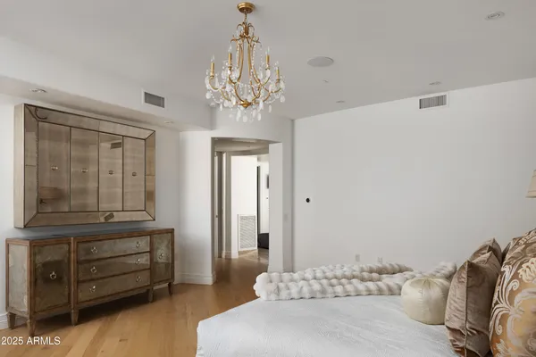 a bedroom with a bed and a chandelier