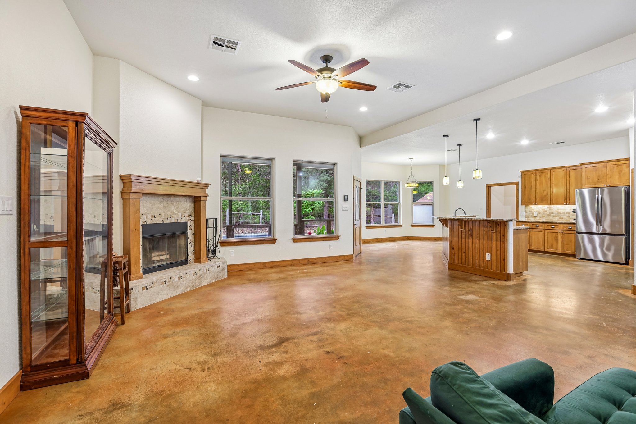 267 Corral Road Smithville, TX 78957 - Photo 14 of 40 Expansive living area featuring stained concrete flooring and a tiled fireplace with a wooden mantle