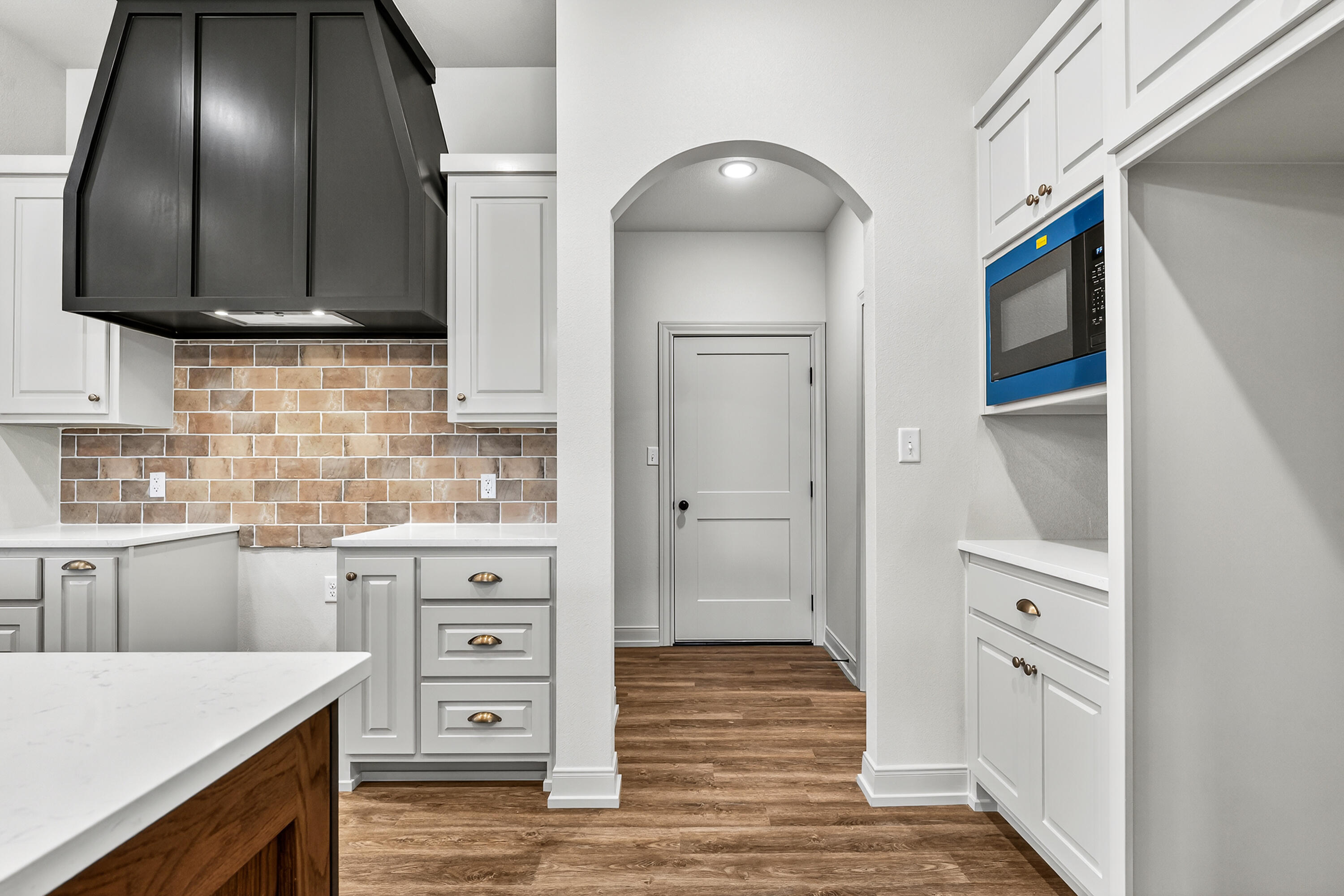 3627 119th Street Lubbock, TX 79423 - Photo 9 of 37 a kitchen with cabinets and wooden floor