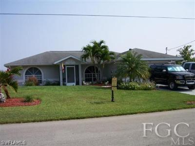8473 Grove Road Fort Myers, FL 33967 - Photo 1 of 1 a front view of a house with a garden and trees