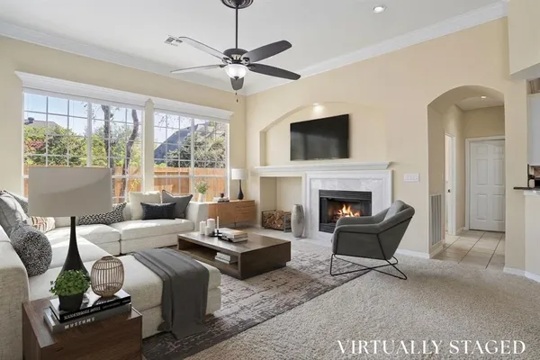 a living room with furniture a fireplace and a large window