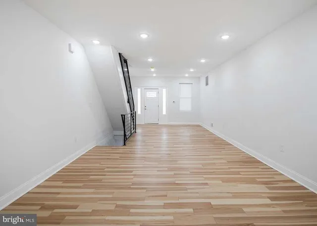 a view of empty room with wooden floor