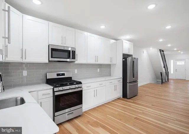 a kitchen with stainless steel appliances a stove microwave and sink