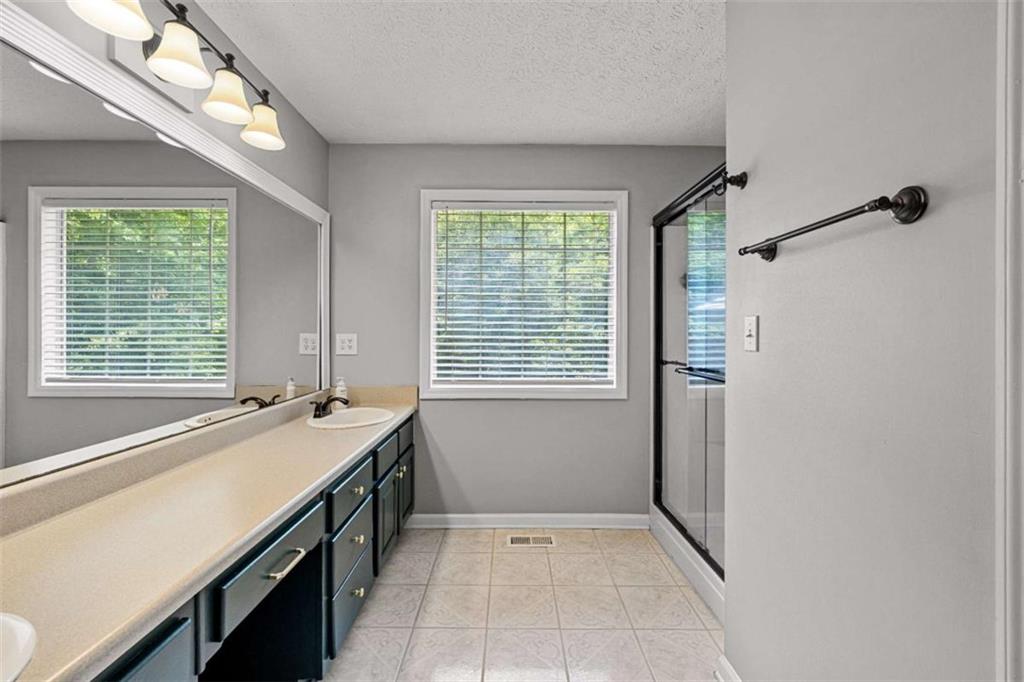 128 Byrom Road Senoia, GA 30276 - Photo 28 of 83 a spacious bathroom with a granite countertop sink a large mirror and a bathtub