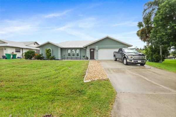 a front view of a house with a garden and yard
