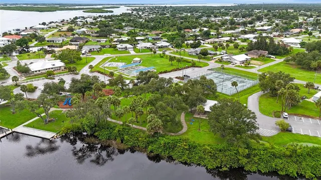 an aerial view of residential houses with outdoor space and trees