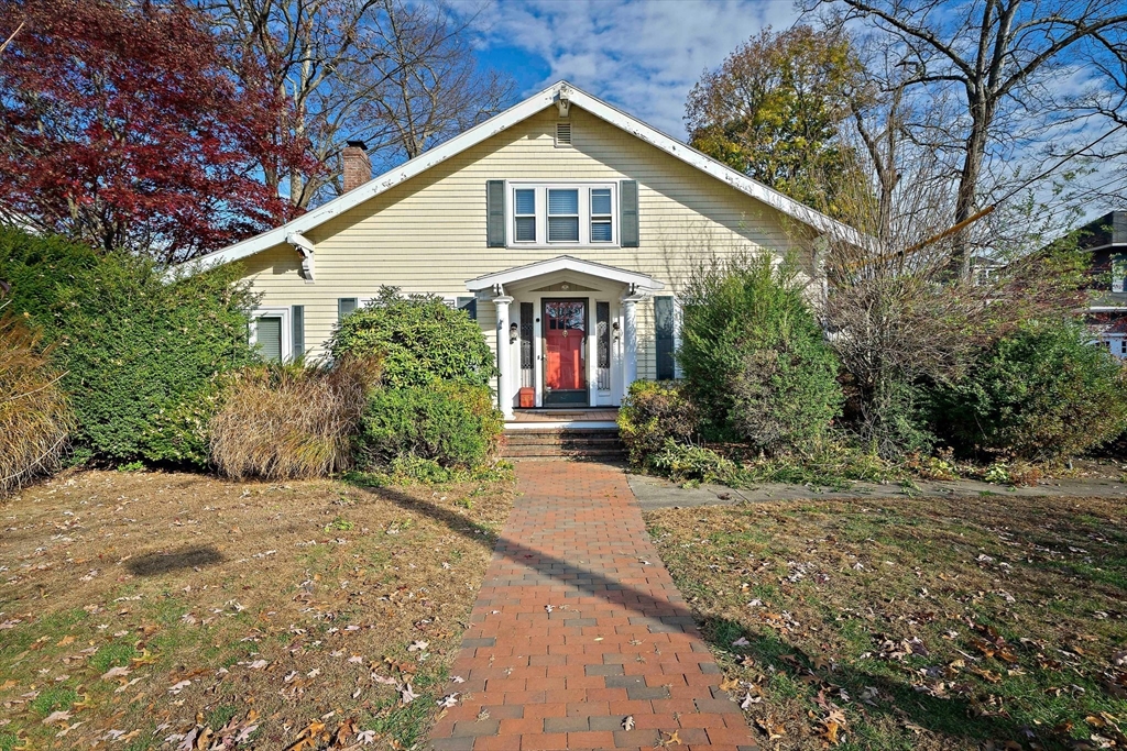 a front view of a house with a yard and trees