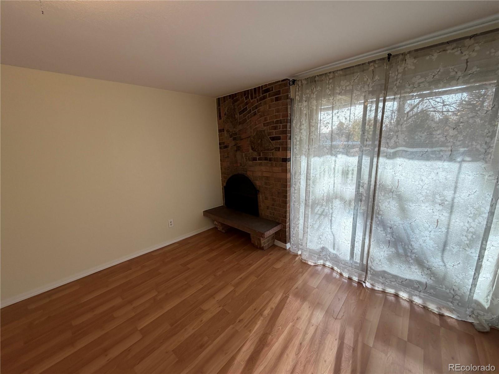 1304 South Parker Road, Unit 258 Denver, CO 80231 - Photo 3 of 9 a view of an empty room with wooden floor and a window