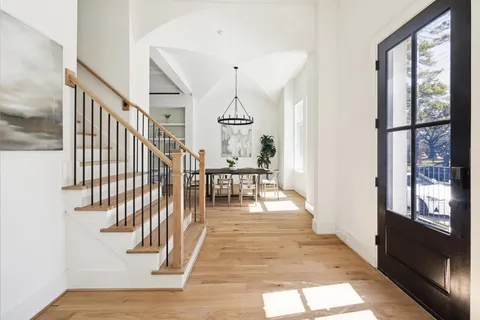 a view of a kitchen with kitchen island a sink wooden floor and living room view