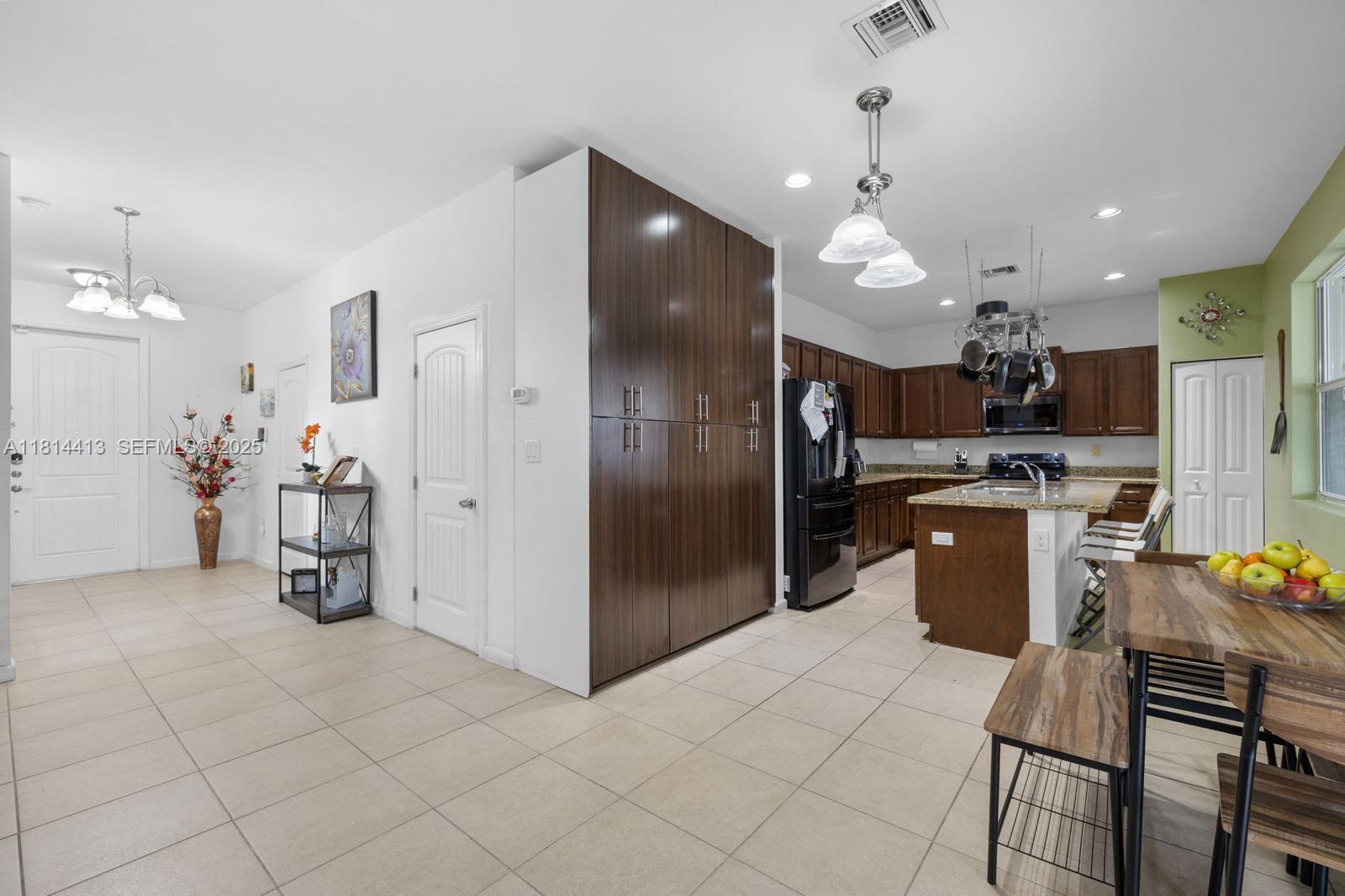 11501 Southwest 228th Lane Miami, FL 33170 - Photo 25 of 44 a kitchen with stainless steel appliances kitchen island granite countertop a refrigerator and a sink