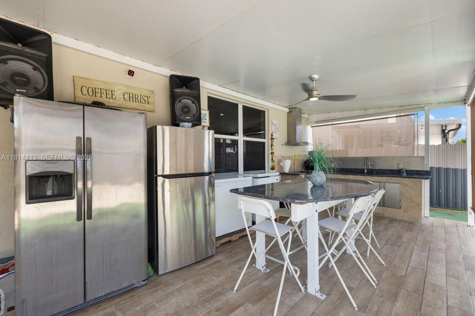 11501 Southwest 228th Lane Miami, FL 33170 - Photo 30 of 44 a kitchen with stainless steel appliances a refrigerator a stove a kitchen island with a stove and white cabinets