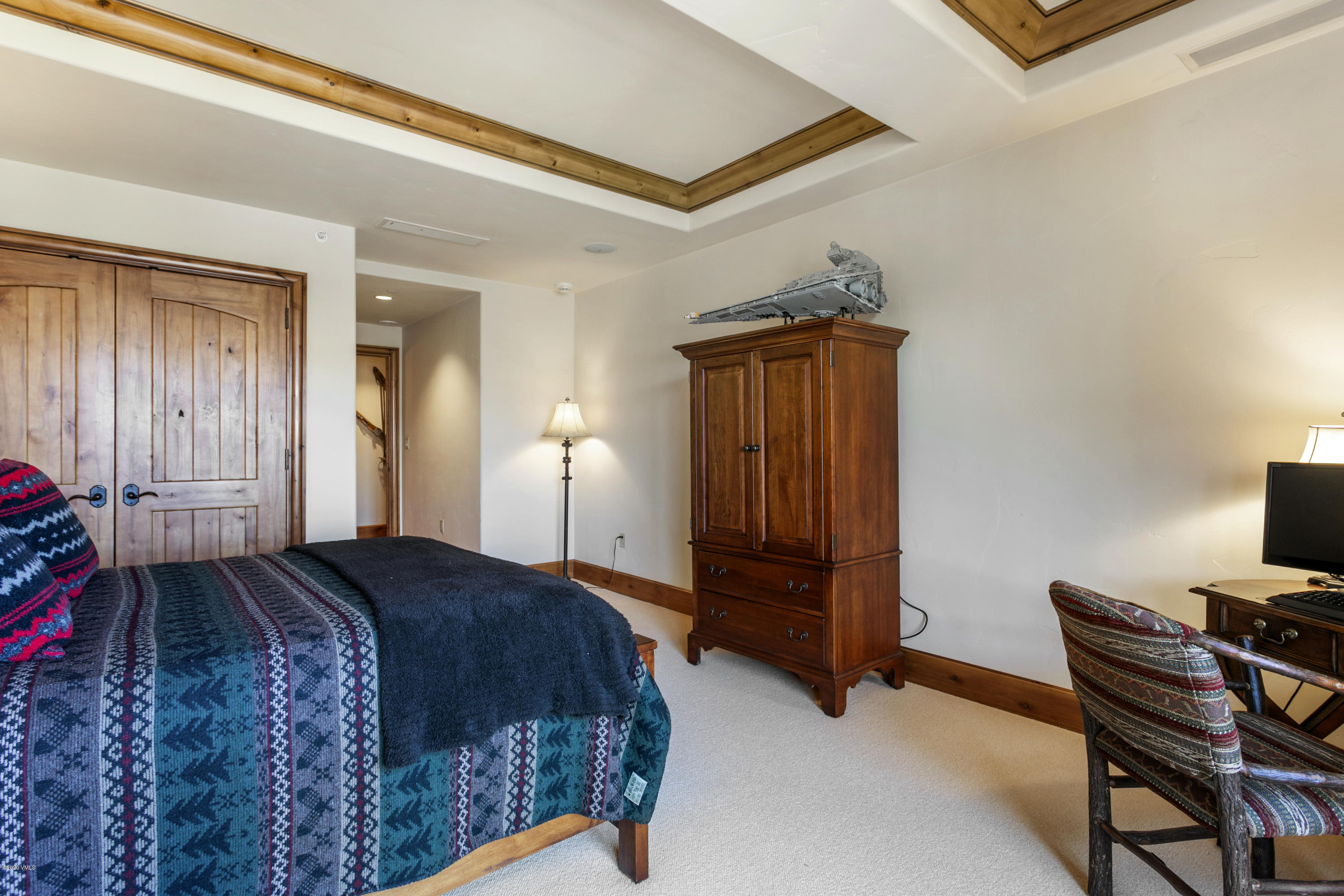 130 Daybreak Ridge Road, Unit R906 Avon, CO 81620 - Photo 18 of 26 a bedroom with a bed and a bookshelf