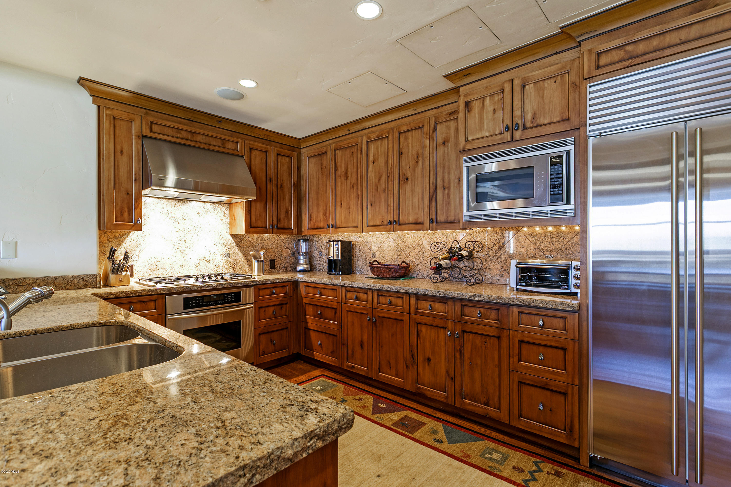 130 Daybreak Ridge Road, Unit R906 Avon, CO 81620 - Photo 5 of 26 a kitchen with stainless steel appliances granite countertop a sink stove and refrigerator