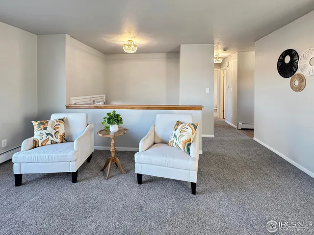 a living room with furniture and a wall painting