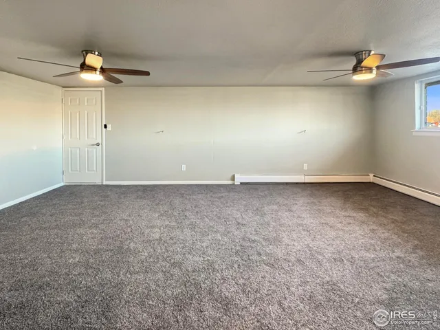 an empty room with a ceiling fan and a window