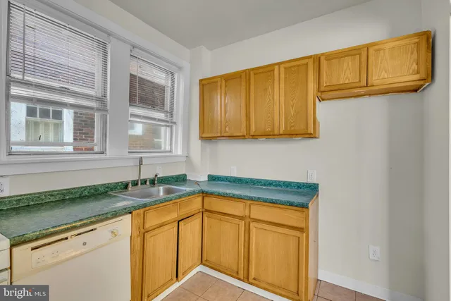 a kitchen with granite countertop cabinets sink and window