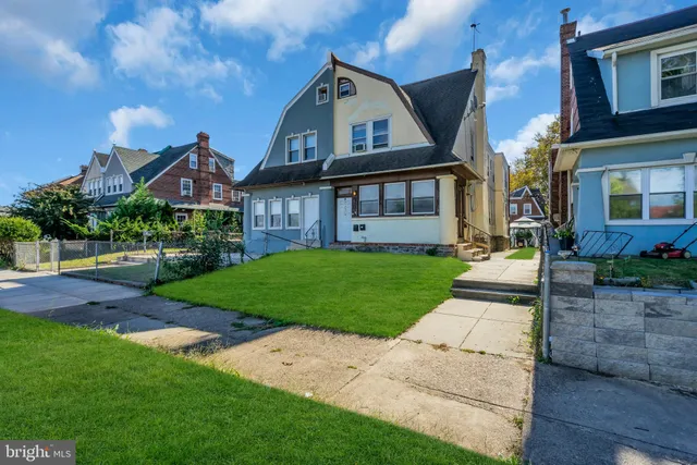 a front view of a house with a yard and potted plants