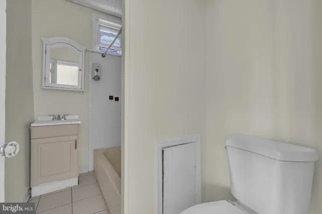 a bathroom with a toilet sink and mirror