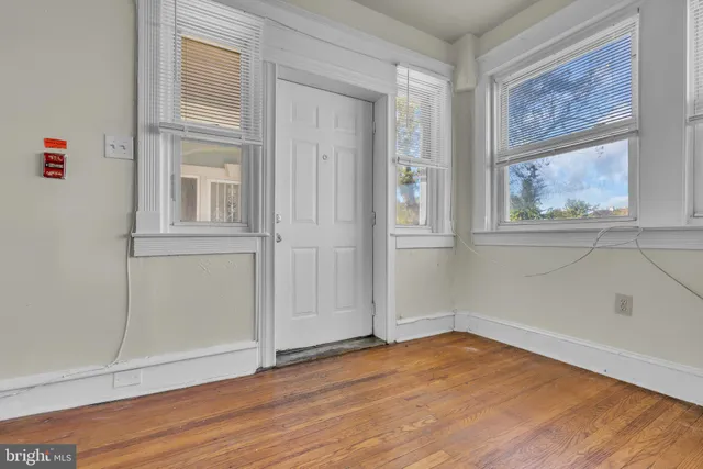 an empty room with wooden floor and window