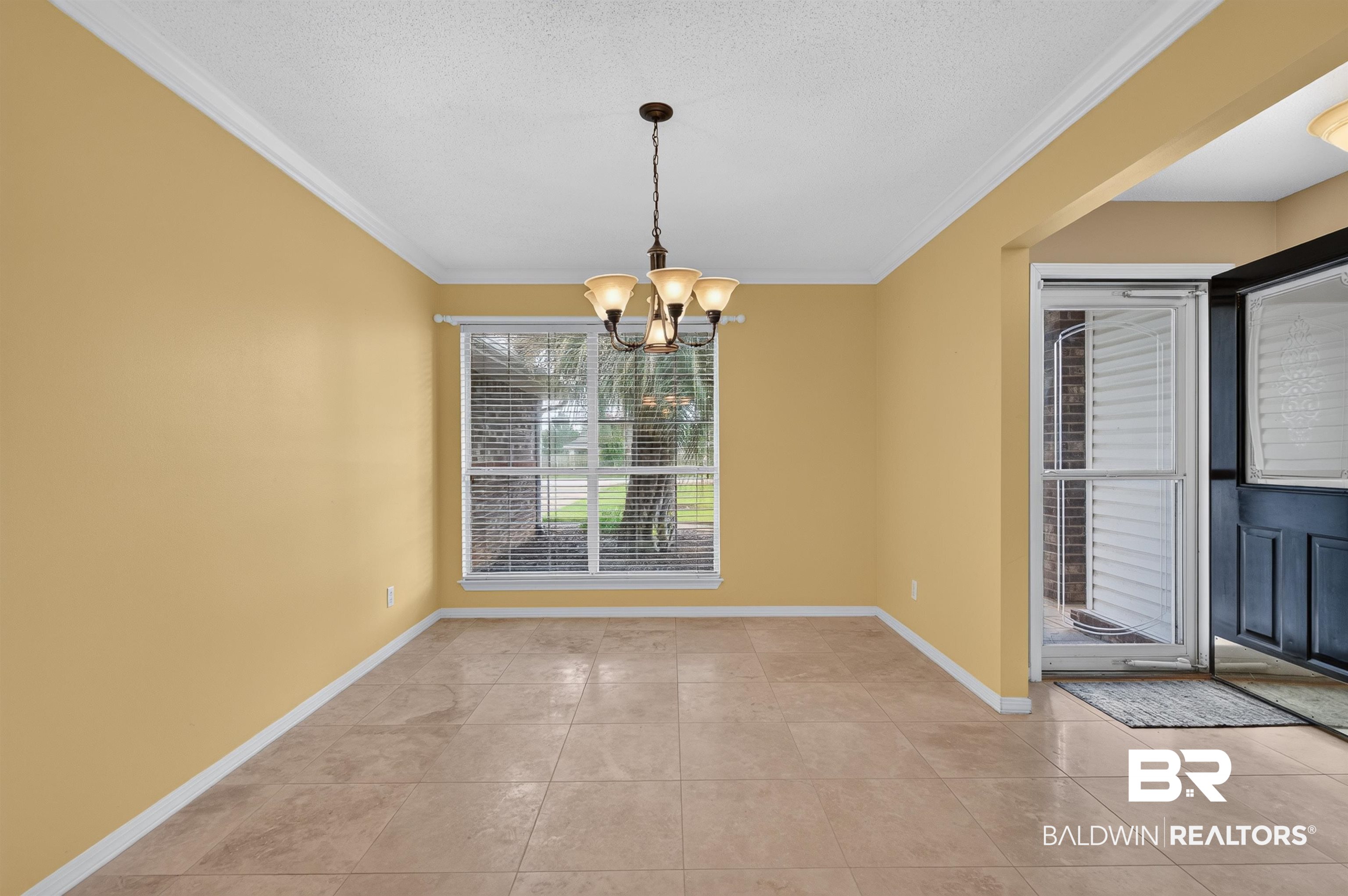 22685 County Road 12 Foley, AL 36535 - Photo 29 of 89 Spacious room featuring neutral tile flooring, a large window with blinds, and crown molding
