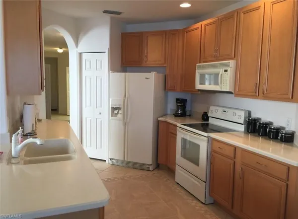 a kitchen with a refrigerator sink and cabinets