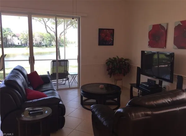 a living room with furniture and a floor to ceiling window