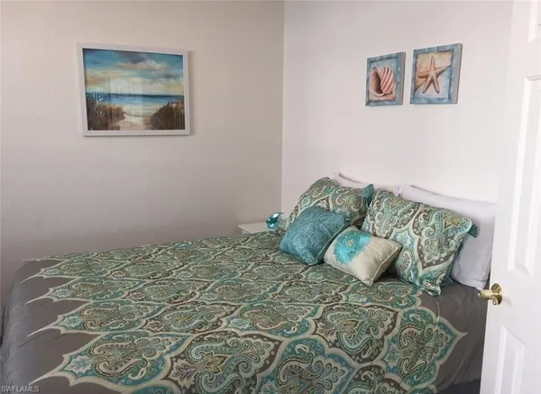 a bedroom with a bed and a painting on the wall