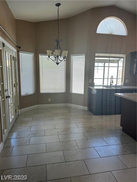 2600 Shakespeare Road Las Vegas, NV 89108 - Photo 3 of 6 An inviting eat-in kitchen with vaulted ceilings, featuring large format tile flooring and abundant natural illumination.