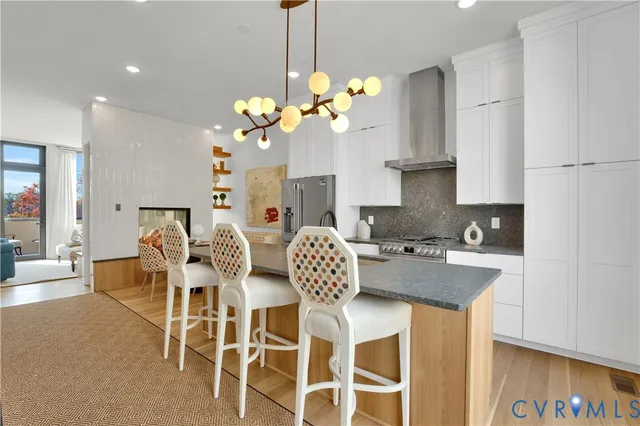 a dining room with stainless steel appliances granite countertop a dining table chairs and a chandelier