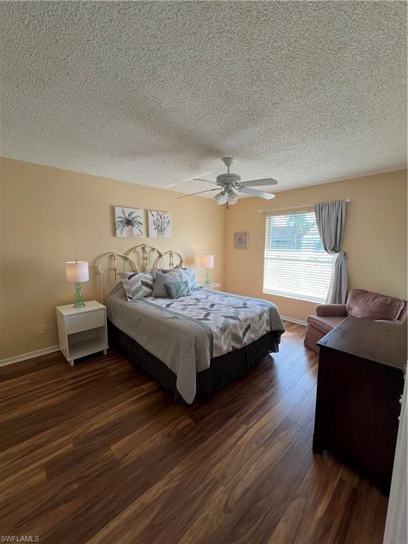 185 Grand Oaks Way, Unit R204 Naples, FL 34110 - Photo 11 of 18 a bedroom with a bed and wooden floor