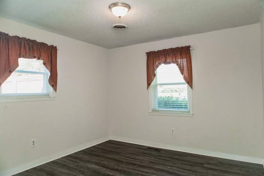 457 Maple Circle Hickory Flat, MS 38633 - Photo 11 of 24 an empty room with wooden floor and windows