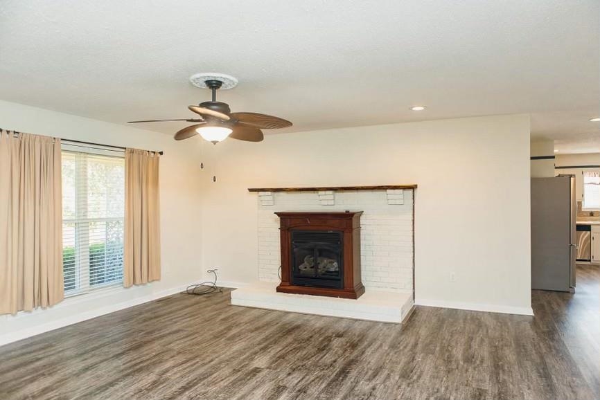 457 Maple Circle Hickory Flat, MS 38633 - Photo 4 of 24 a view of an empty room with wooden floor fireplace and a window