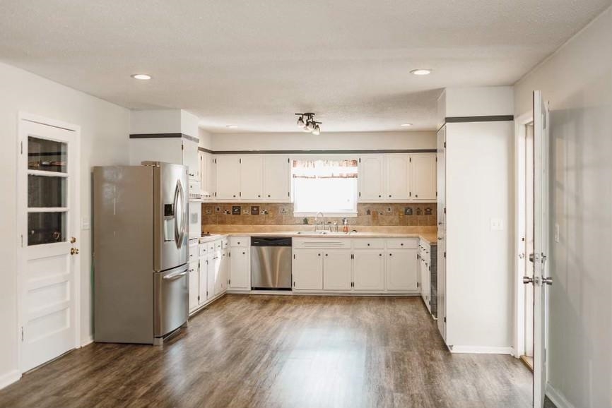 457 Maple Circle Hickory Flat, MS 38633 - Photo 7 of 24 a kitchen with a refrigerator a sink and dishwasher with wooden floor
