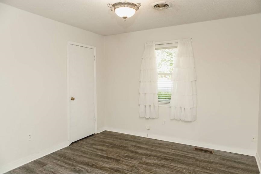 457 Maple Circle Hickory Flat, MS 38633 - Photo 10 of 24 an empty room with wooden floor and windows