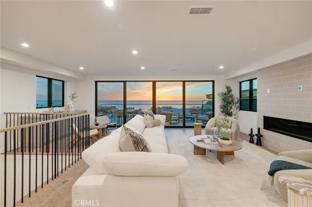 a living room with furniture tv and floor to ceiling windows