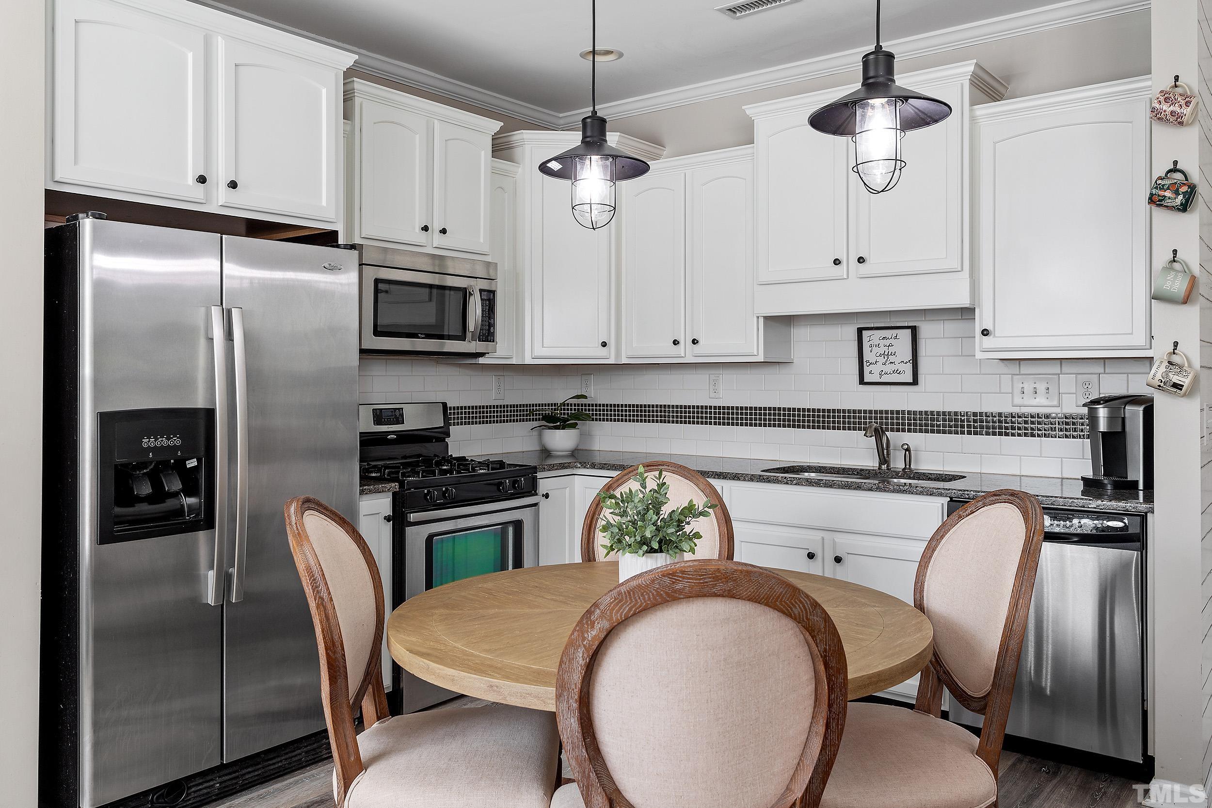 2463 Memory Ridge Drive Raleigh, NC 27606 - Photo 11 of 34 a kitchen with stainless steel appliances granite countertop a refrigerator a stove a sink and white cabinets