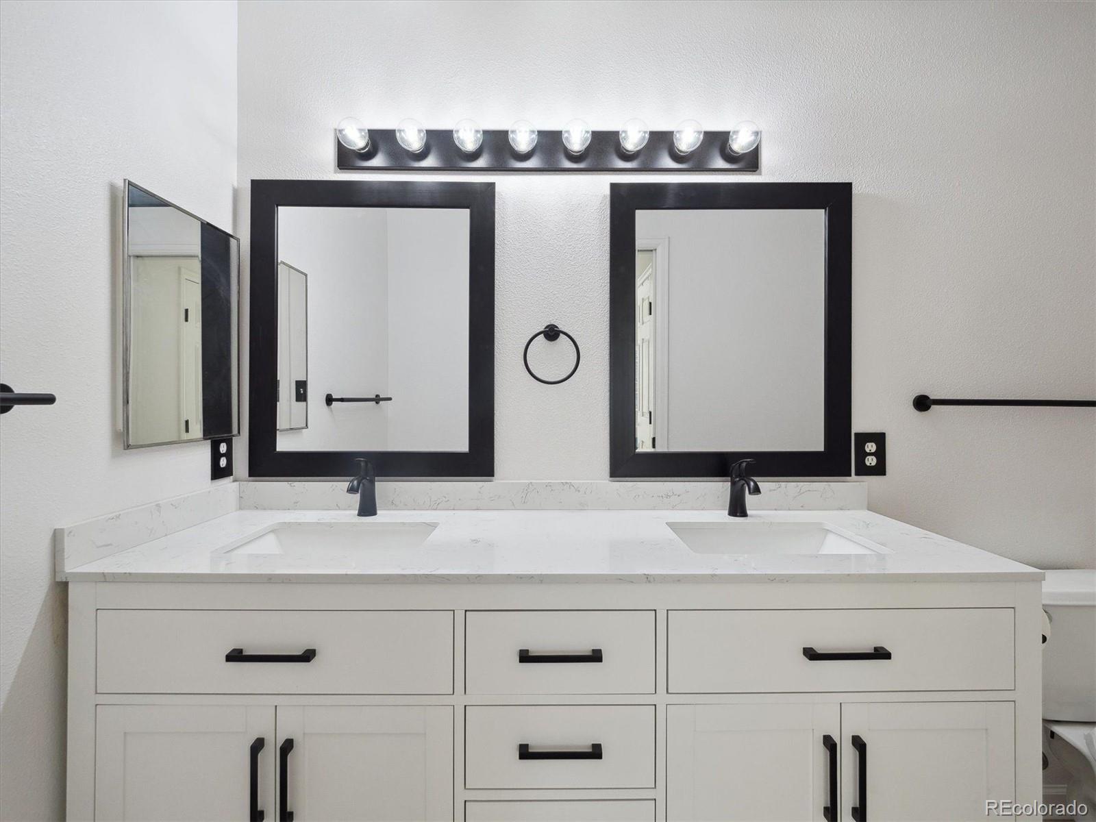 3855 East Canyon Ranch Road, Unit 104 Highlands Ranch, CO 80126 - Photo 11 of 18 a bathroom with double vanity sink and mirror