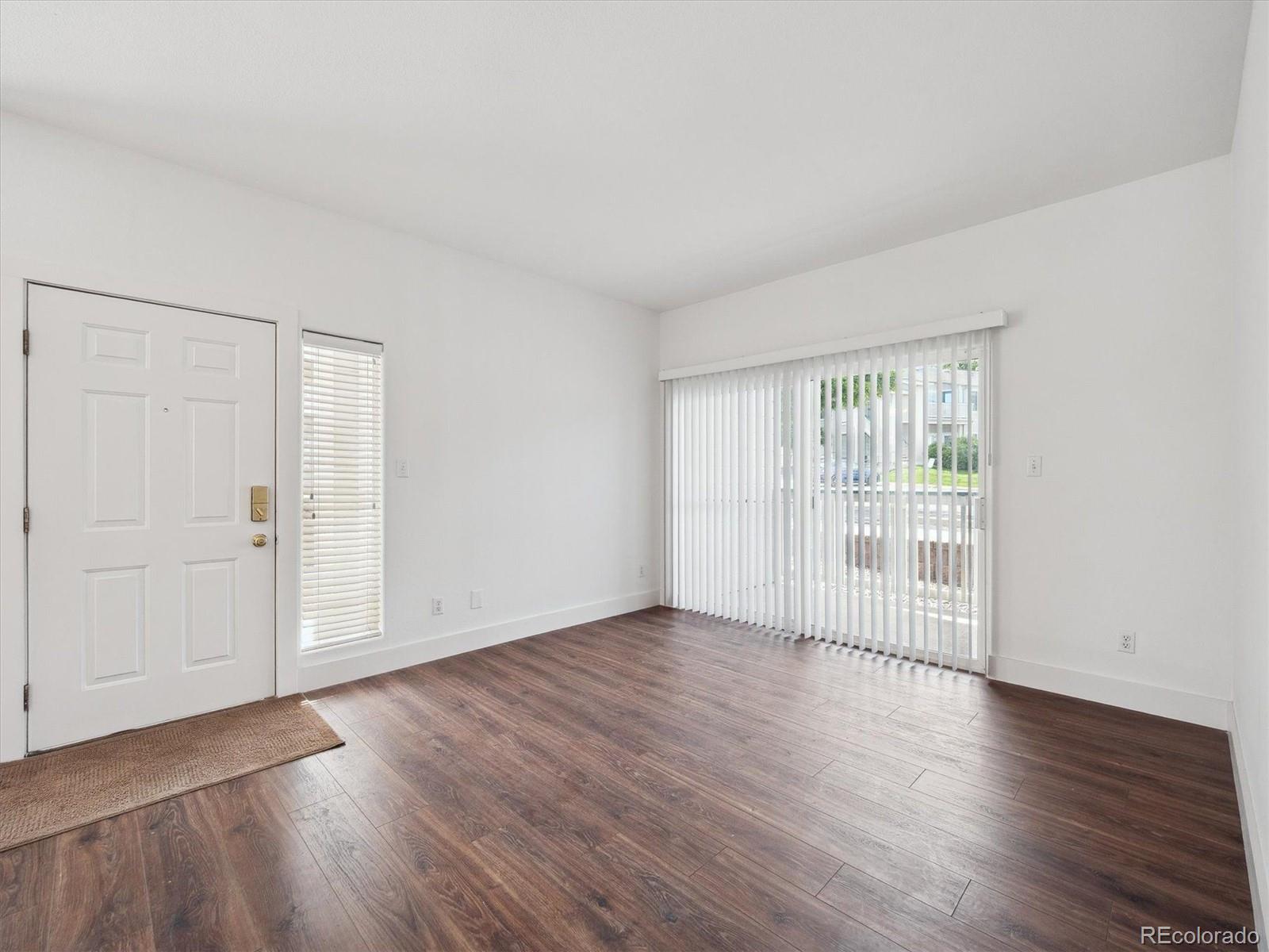 3855 East Canyon Ranch Road, Unit 104 Highlands Ranch, CO 80126 - Photo 2 of 18 a view of an empty room with wooden floor and a window