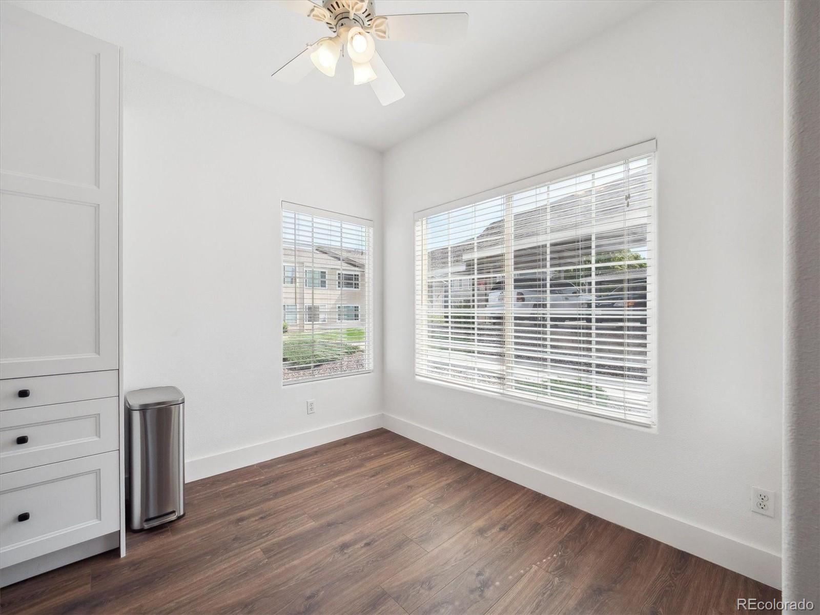 3855 East Canyon Ranch Road, Unit 104 Highlands Ranch, CO 80126 - Photo 6 of 18 a view of an empty room with wooden floor and a window
