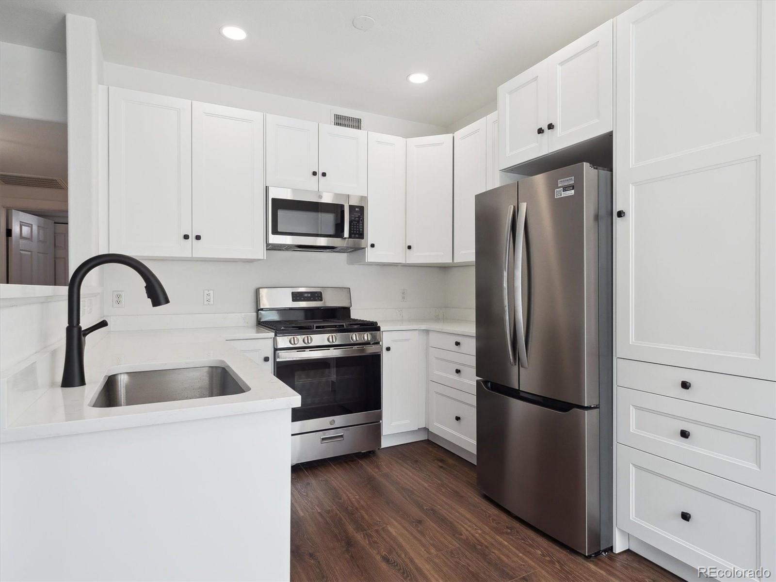 3855 East Canyon Ranch Road, Unit 104 Highlands Ranch, CO 80126 - Photo 7 of 18 a kitchen with stainless steel appliances granite countertop a refrigerator sink and stove