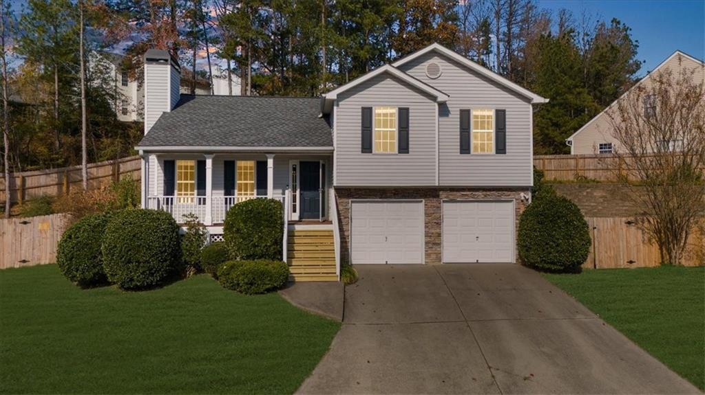 203 Bainbridge Way Dallas, GA 30132 - Photo 1 of 38 a front view of a house with a garden and plants