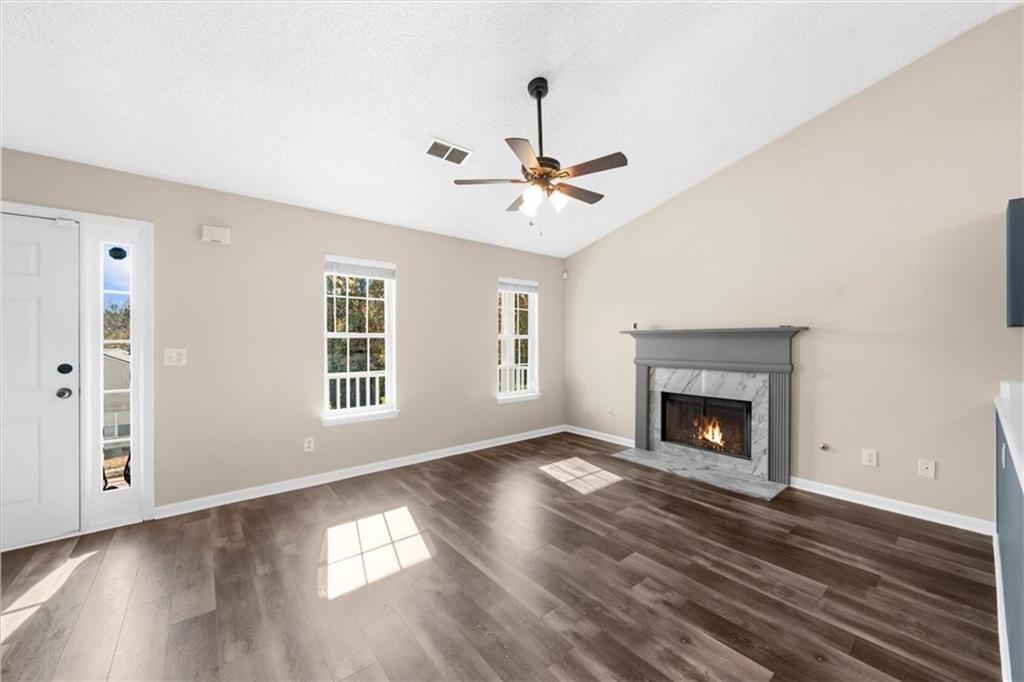 203 Bainbridge Way Dallas, GA 30132 - Photo 5 of 38 a view of an empty room with wooden floor fireplace and a window